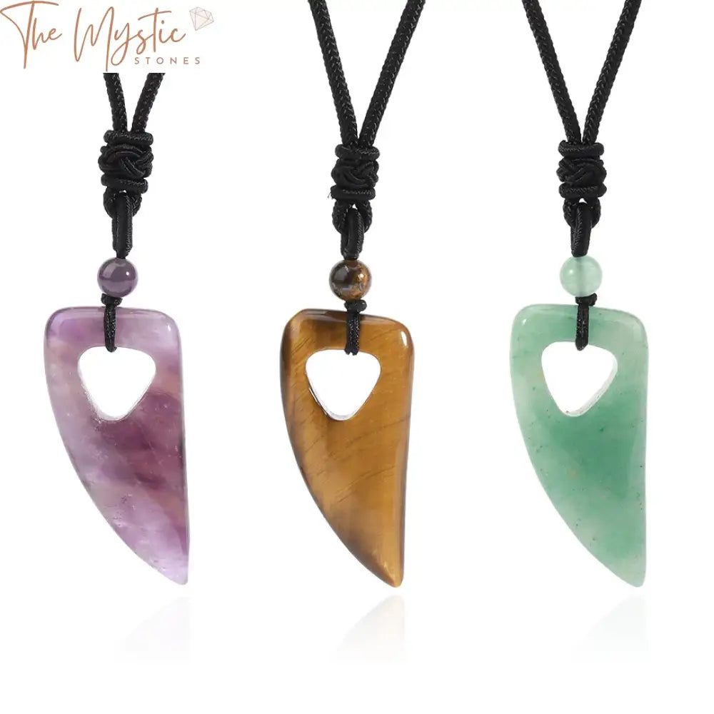 A rustic, wolf tooth-shaped crystal pendant necklace made from natural tiger eye and amethyst quartz stones.