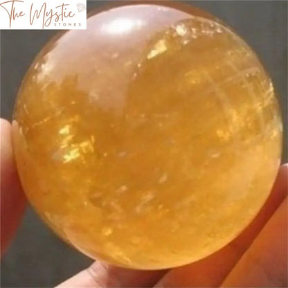 A 40mm yellow natural citrine calcite quartz crystal sphere is shown, radiating a warm golden hue.