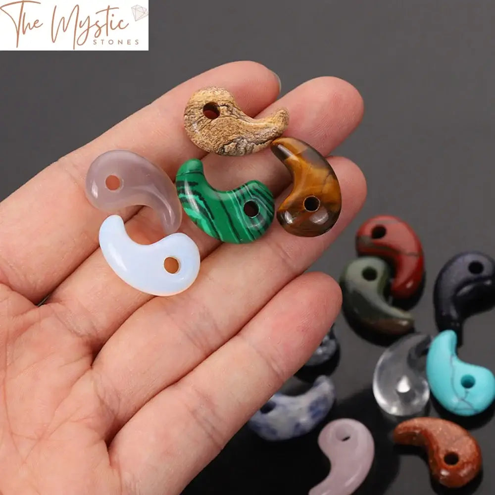 A close-up image of two intertwined stone pendants shaped like a yin and yang symbol.