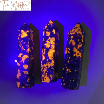 A hexagonal Yooperlite Quartz obelisk stands upright, showcasing its smooth surfaces and natural speckled patterns.